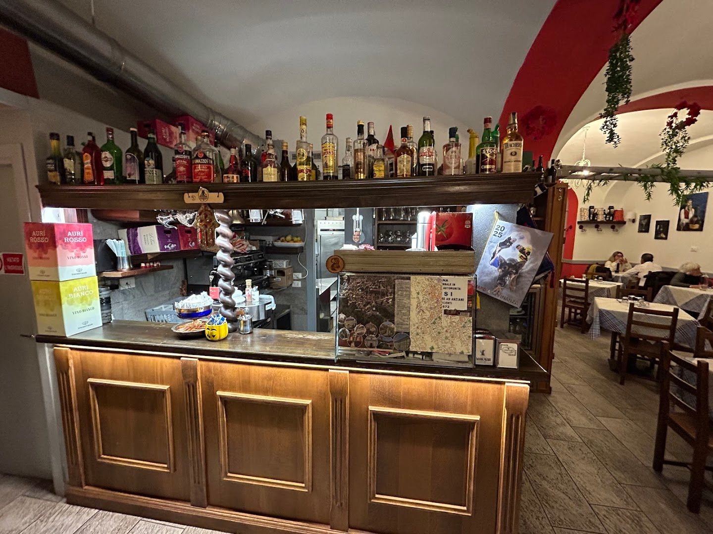 Il bancone in legno e la sala con le volte della trattoria